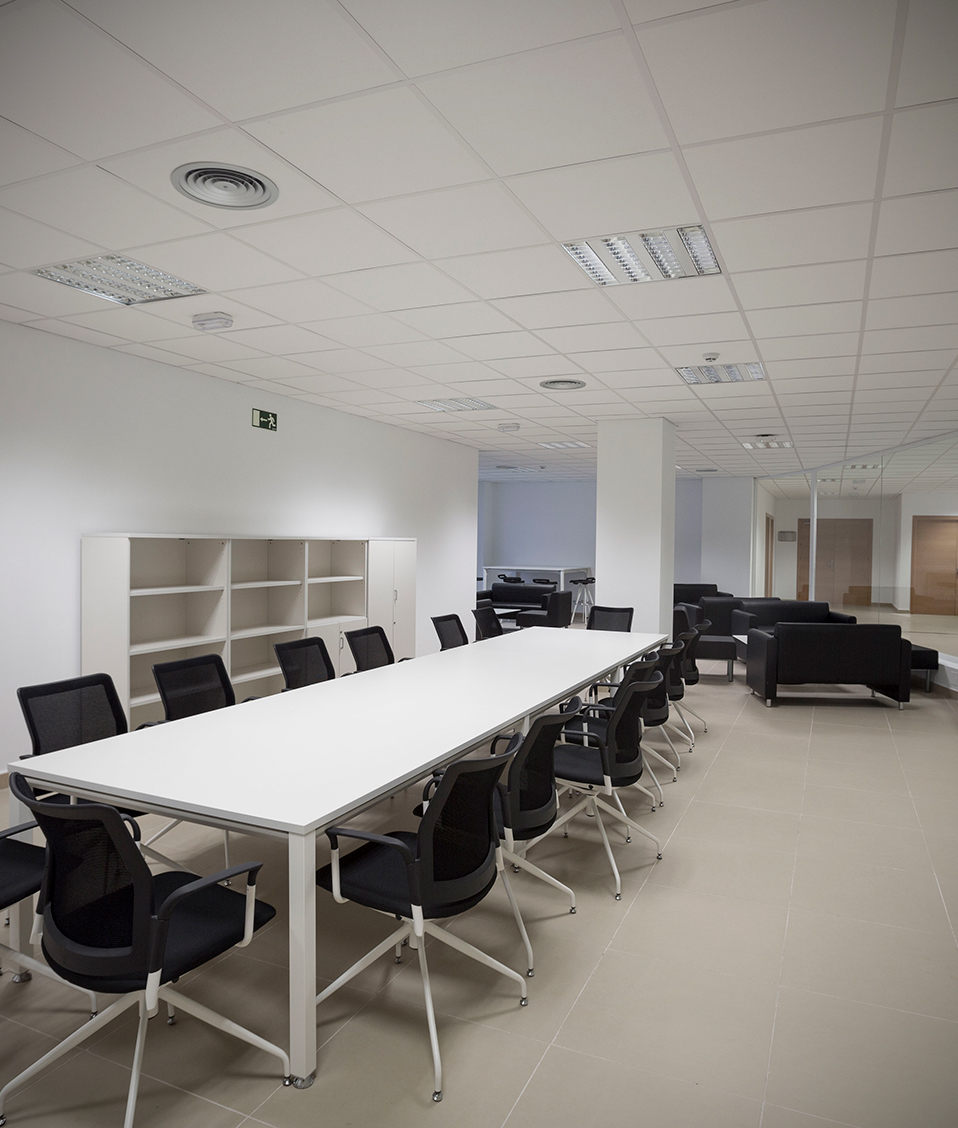 Vista del interior de la sala de reuniones del CETIC donde se ve una gran mesa rodeada de sillas y sofás al fondo